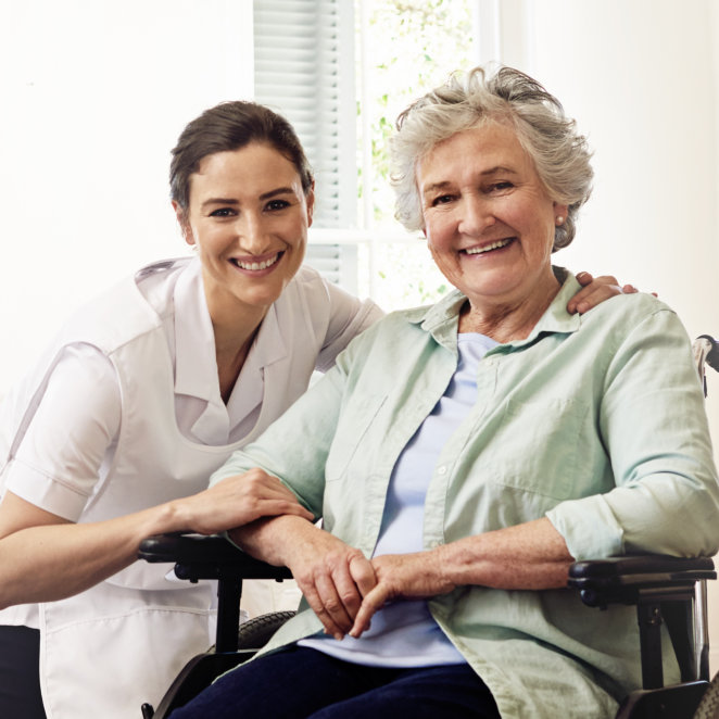 a caregiver and an elderly woamn smiling